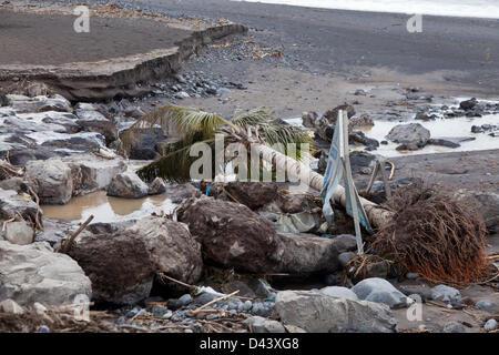 Cleaning up after storm damage in Playa de San Juan, Guia de Isora, Tenerife, Canary Islands. Winds of up to 100 km/hour and extremely high rainfall caused flooding bringing lots of mud and other debris on to the beach promenade and walkways of San Juan. Stock Photo