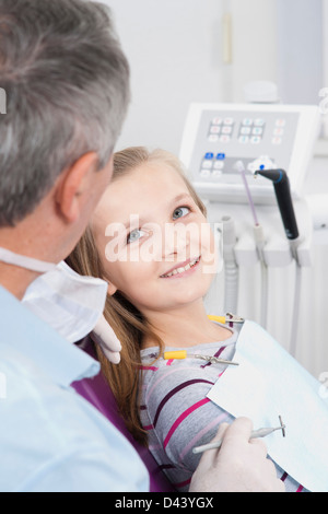 Girl looking up at Dentist during Appointment, Germany Stock Photo