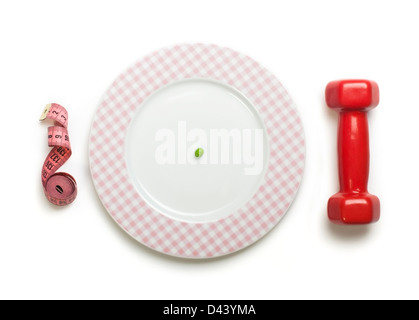 Plate with one peas. Dumbbell and centimeter measure. Studio shot Stock Photo