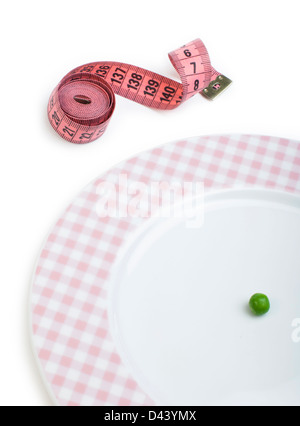 Plate with one peas. Dumbbell and centimeter measure. Studio shot Stock Photo