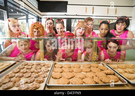 Women Wearing Devil Horns at a Bakery, Oakland, Alameda County, California, USA Stock Photo