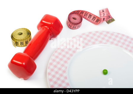 Plate with one peas. Dumbbell and centimeter measure. Studio shot Stock Photo