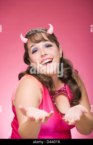 Portrait of Woman Wearing Devil Horns Reaching Out Stock Photo