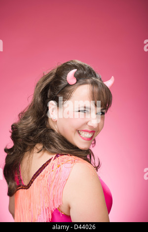 Portrait of Woman Wearing Devil Horns and Smiling Stock Photo