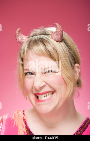 Portrait of Woman Wearing Devil Horns and Scowling Stock Photo
