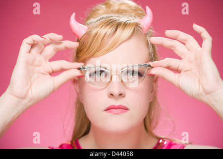 Portrait of Woman Wearing Devil Horns and Vintage Eyeglasses Stock Photo