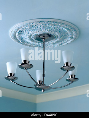 Plaster ceiling rose and modern chrome and glass light fitting Stock Photo