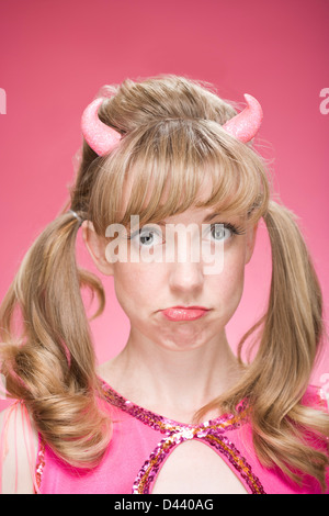 Portrait of Woman Wearing Devil Horns and Making Faces Stock Photo