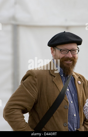 Smiling man with beard and glasses in beret and brown corduroy jacket Stock Photo