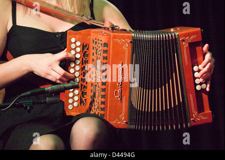 Horizontal close up of a traditional Irish accordionist playing on stage. Stock Photo