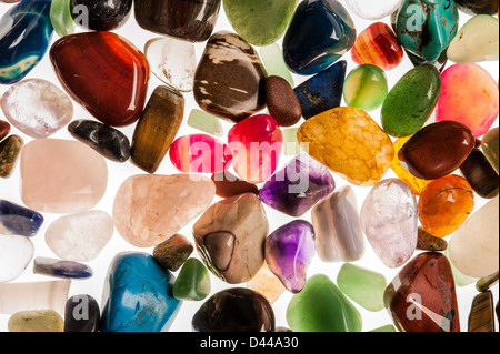 Assortment of polished semi-precious gem stones shot in the studio against white background. Stock Photo