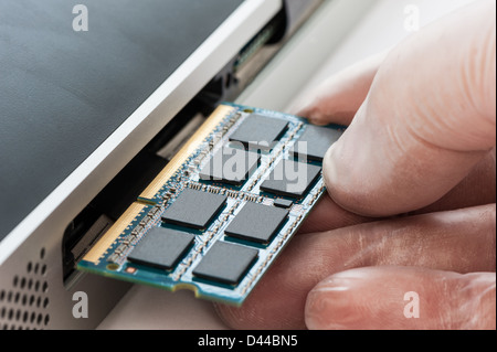 IT Technician replacing a random access memory (RAM) board in a computer. Stock Photo