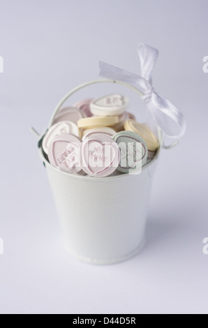 Love heart sweets in a little bucket with bow. Stock Photo