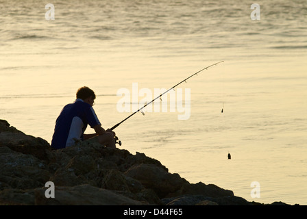 fisherman on Venice, Florida jetty at sunset Stock Photo