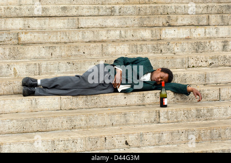 Drunk man sleeping on church steps Stock Photo
