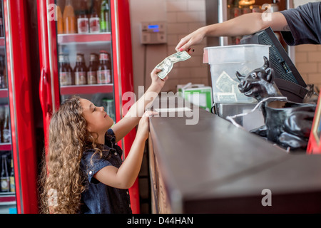 Mixed race girl buying food in restaurant Stock Photo