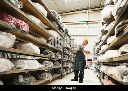 Worker checking product in manufacturing plant Stock Photo