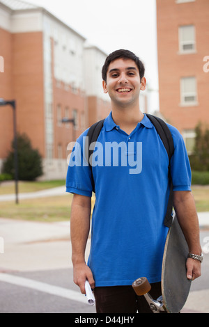 Middle Eastern student carrying skateboard Stock Photo