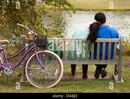Student couple sitting on park bench Stock Photo
