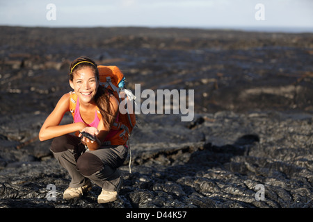 Portrait of young woman showing fresh cooled lava from Kilauea volcano around Hawaii volcanoes national park Stock Photo