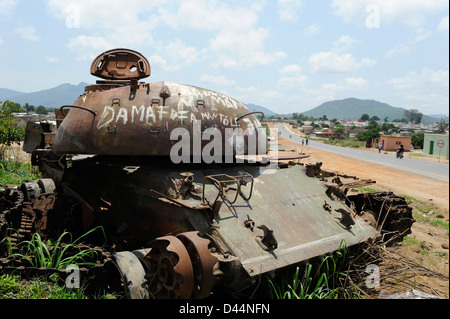 Africa ANGOLA, wreck of old soviet russian battle tank T-55 from civil war between MPLA and UNITA in Quibala at street crossing Stock Photo