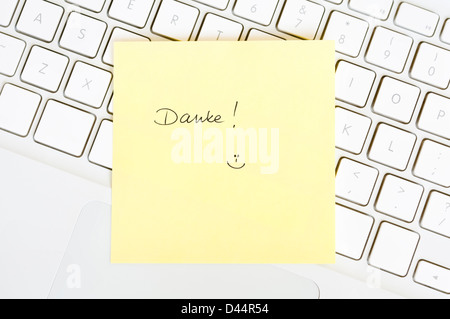 Postit note saying Danke arranged on a laptop keyboard Stock Photo