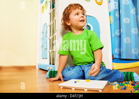 Happy two years old boy solving puzzle mosaic game Stock Photo