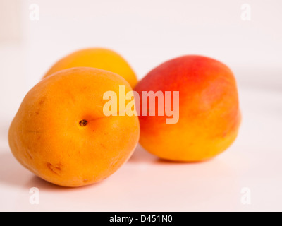 The apricot fruit is a drupe similar to a small peach, from yellow to orange, often tinged red on the side most exposed to the sun; its surface can be smooth or velvety with very short hairs. The flesh is usually firm and not very juicy.Its taste can range between sweet to tart. Stock Photo