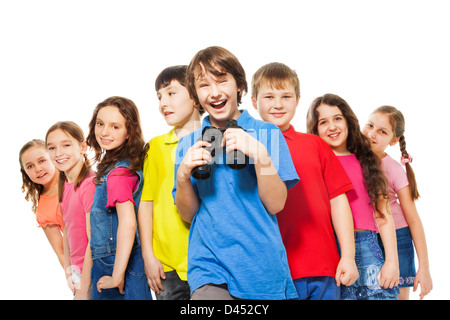Big group of kids with confident happy boy holding binoculars and laughing Stock Photo