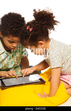 Black boy and girl playing with digital tablet computer and looks very busy Stock Photo