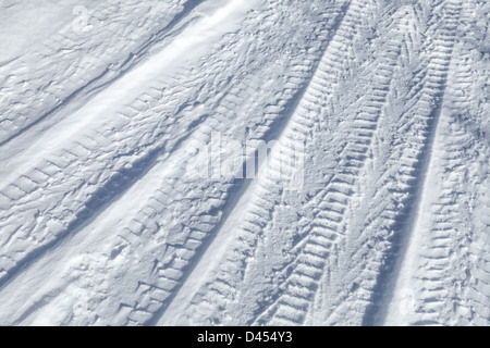 Background texture of tire tracks on road covered with snow Stock Photo