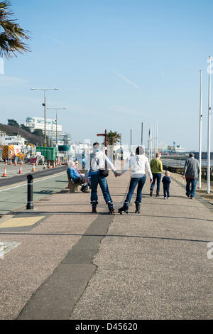 Southend, Essex, UK. 5th March 2013. People enjoy the unseasonably warm day. A young couple roller skate along Southend seafront while holding hands.  Credit:  Allsorts Stock Photo / Alamy Live News Stock Photo