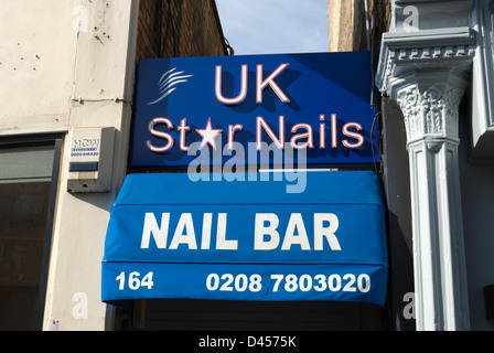 sign and awning for a nail bar, or manicuirsts, squeezed into a gap between  buildings in putney, southwest london, england Stock Photo