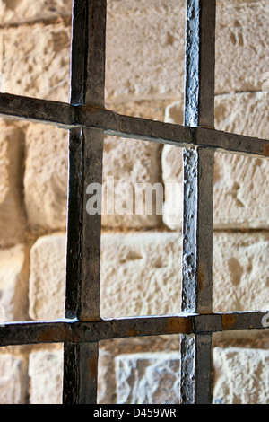 Prison bars on window in Caernarfon Castle with stone background Gwynedd Wales UK Stock Photo