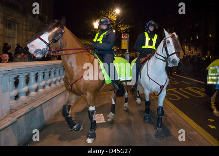 Police horses and riders in full riot gear advancing down Whitehall at night, Day X3 Student Demonstration, London, England Stock Photo