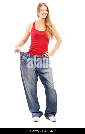 Full length portrait of a weigh loss female with old pair of jeans, isolated on white Stock Photo