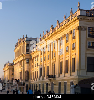 Schonbrunn at Sunset. The bright yellow palace glows as the the sun sets over the gardens. Stock Photo