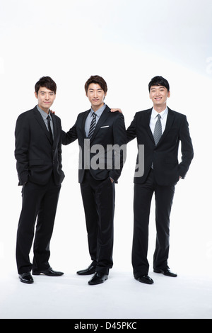 three businessmen in buisness suits posing in a line Stock Photo - Alamy