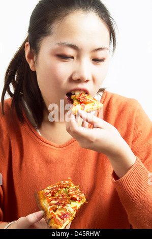 Asian girl eating delicious pizza. Stock Photo