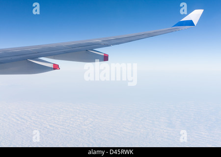 Winglet of an aircraft Airbus A330-300 of China Airlines CI-917 in flight, above stratocumulus clouds, against blue sky, fly from Taiwan to Hong Kong