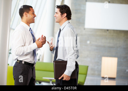 Two Businessmen Having Informal Meeting In Modern Office Stock Photo