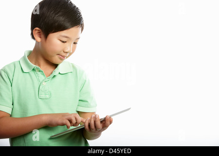 Studio Shot Of Chinese Boy With Digital Tablet Stock Photo