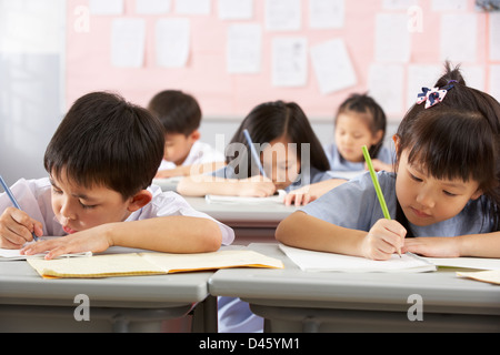 Group Of Students Working At Desks In Chinese School Classroom Stock Photo
