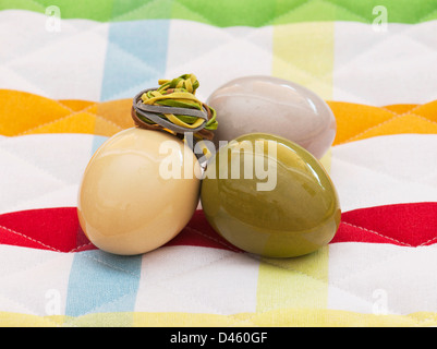 Three easter eggs on patterned fabric. Stock Photo