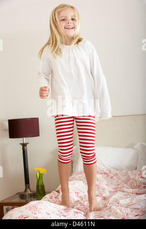 Young Girl Bouncing On Bed Stock Photo