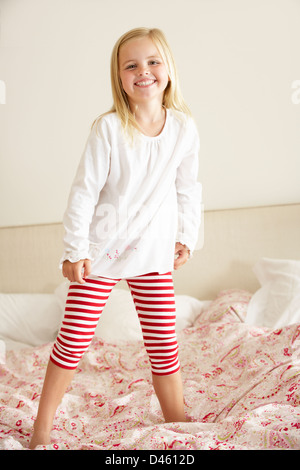 Young Girl Bouncing On Bed Stock Photo