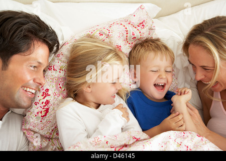 Family Relaxing Together In Bed Stock Photo