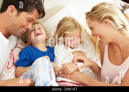 Family Relaxing Together In Bed Stock Photo