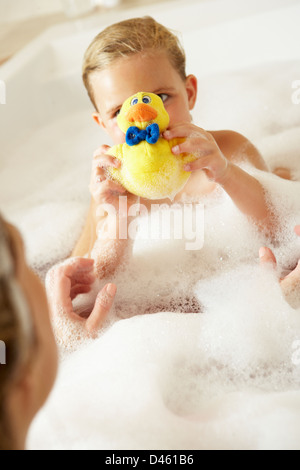 Mother And Daughter Relaxing In Bubble Filled Bath