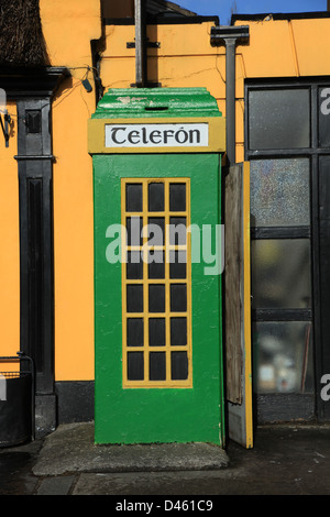 old style telephone box painted in green and gold,  on an irish roadside, irish telephone kiosk common in the irish countryside, Stock Photo